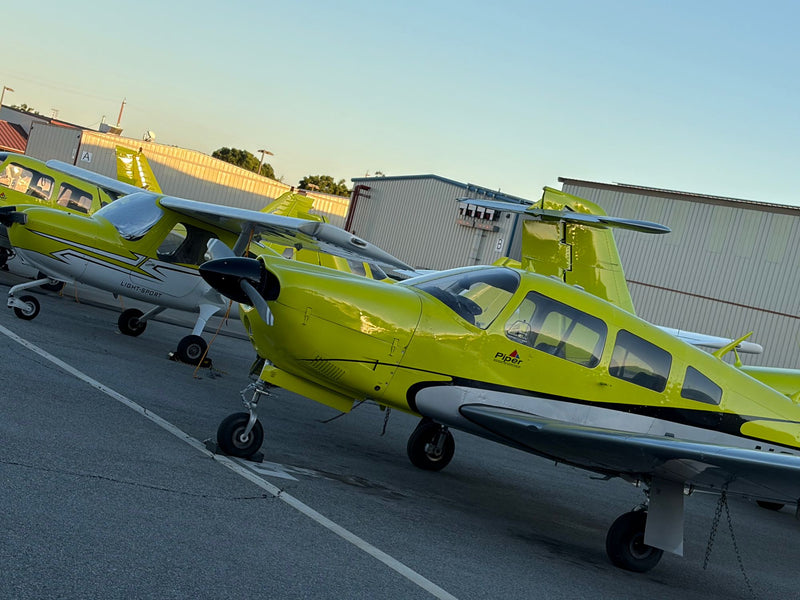 Yellow Piper trainer with Cessna 162s and a Piper Seminole behind on the Van Nuys ramp at dusk