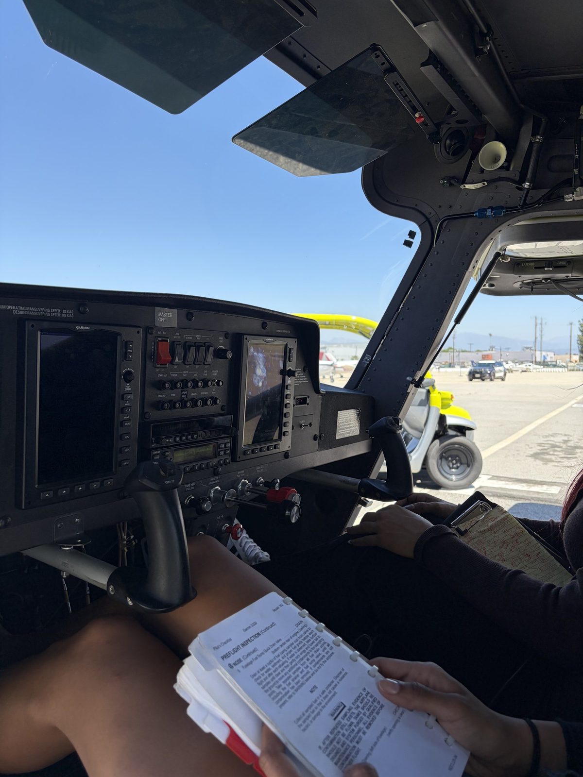 A hand on the Cessna 162 glass panel with a checklist