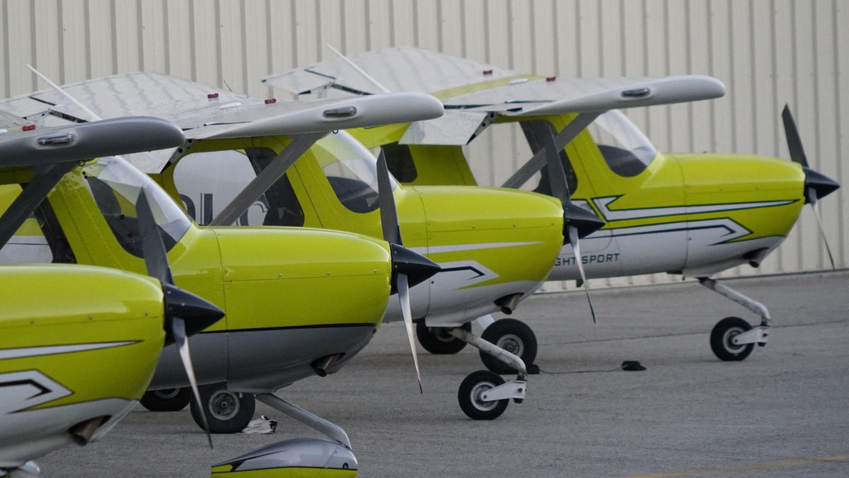 Noses and propellers of Cessna 162 Skycatcher trainers lined up outside a hangar at Van Nuys