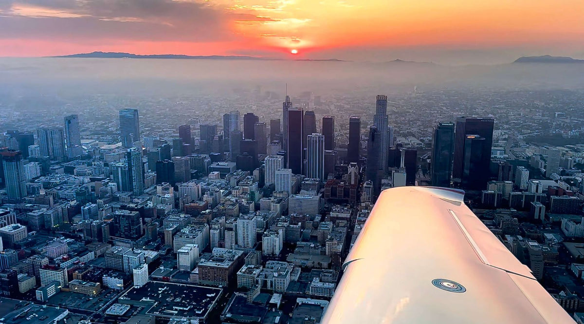 Wing of a training airplane over Los Angeles as evening falls, seen on a night discovery flight for two from Van Nuys