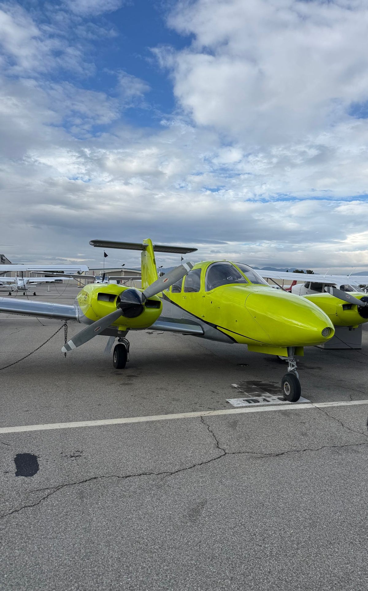 Yellow Piper Seminole twin on the Van Nuys ramp under a sky of white clouds