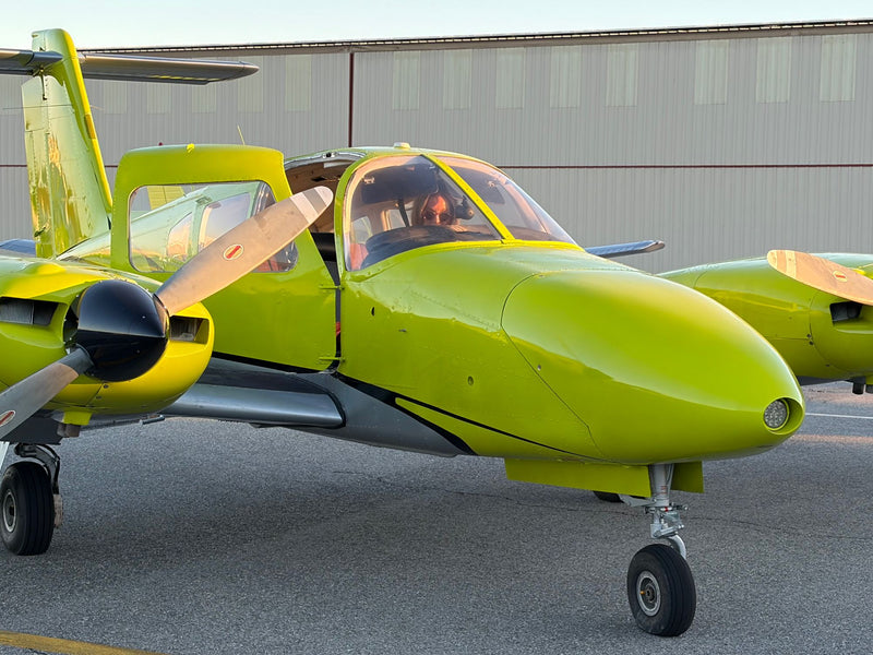 A pilot in the cockpit of the You Fly LA Piper Seminole at golden hour at Van Nuys Airport