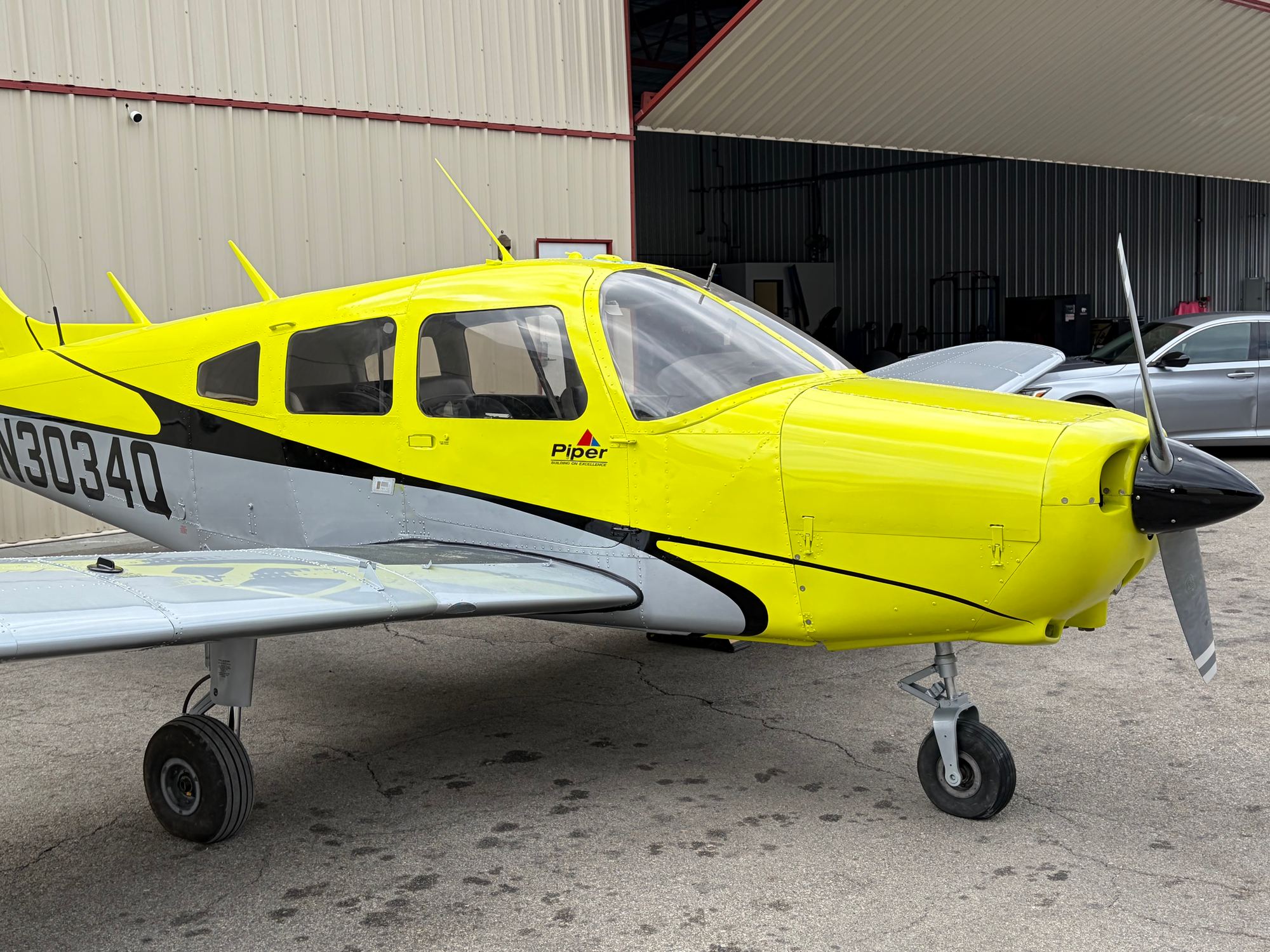 Piper Warrior N3034Q, front quarter, beside an open hangar at Van Nuys Airport