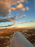 Wing of a training airplane over Los Angeles as the city lights come on at dusk, seen on a night discovery flight from Van Nuys