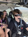 Young passenger in a headset in the front seat flying over Los Angeles